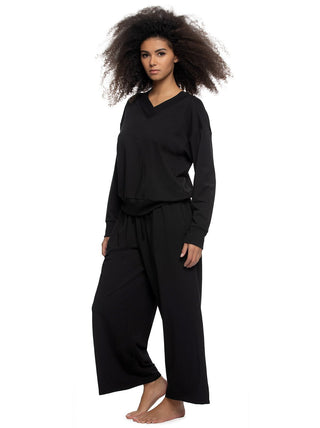 Birta Woman wearing a black terry hooded sweatshirt and pants outfit on a white background