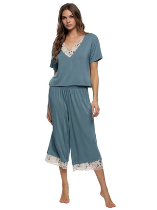 Daria - Woman wearing a teal pajama set  shirt and wide pants with lace trim on a white background