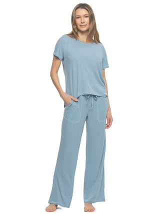 Masha A woman wearing a blue short-sleeved crew neck tee and matching wide-leg pants with a drawstring waistband and cargo pockets.