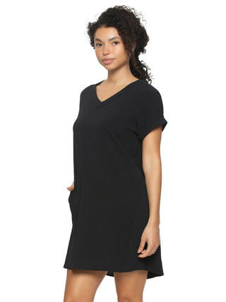 Quinn A woman standing and posing in a black short sleevedress with a V-shaped neckline and side pockets.