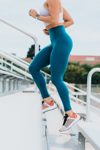 a woman in leggings jogging up a bleachers
