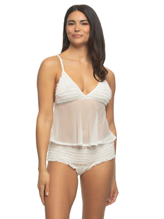 A woman is wearing a white sheer ruffled babydoll lingerie set from Felina.