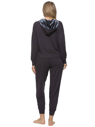 A female model wearing a navy blue 2-piece lounge set with a zip-up hoodie and matching joggers back view hands by sides